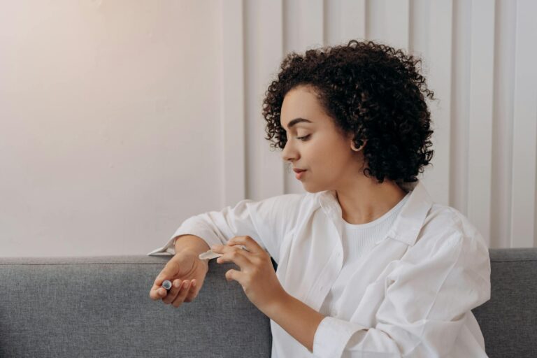 Woman in White Dress Shirt Sitting on Gray Couch